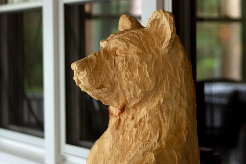 A wooden bear sculpture with intricate detailing.