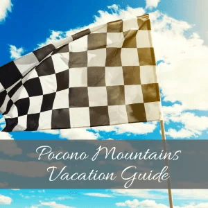 A checkered flag against a blue sky with clouds, featuring the text "Pocono Mountains Vacation Guide."