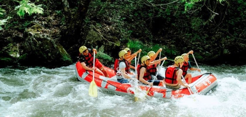 A group paddles through whitewater rapids together during a rafting trip near the Poconos.
