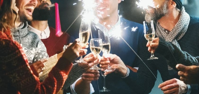 friends toast with champagne glasses and sparklers during a festive new years celebration